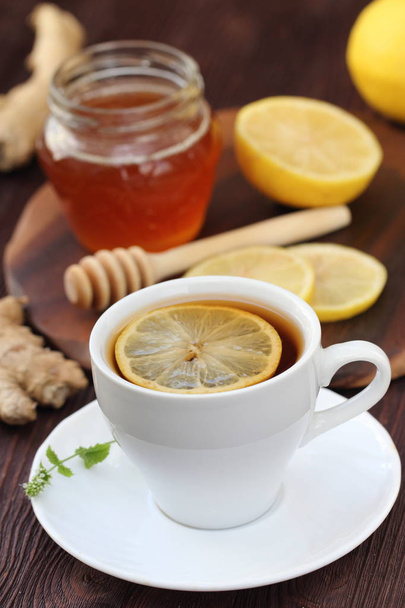 木製テーブルの上のレモンと蜂蜜生姜茶のカップ。ヘルスケア。デトックスド リンク - 写真・画像