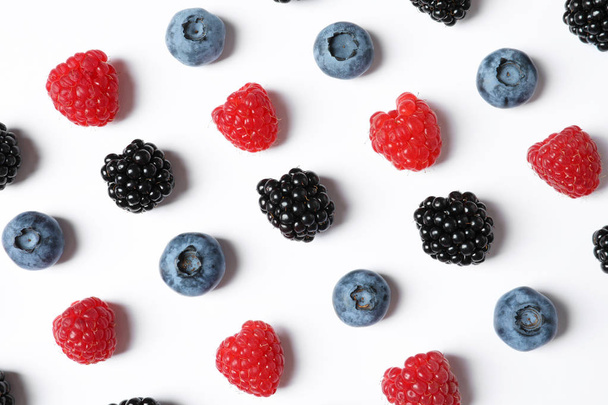 Composition with raspberries, blackberries and blueberries on white background - Fotoğraf, Görsel