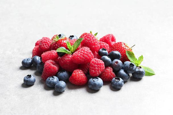 Raspberries, strawberries and blueberries on table - Фото, зображення