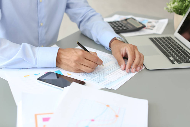 Tax accountant working with documents at table - Photo, Image
