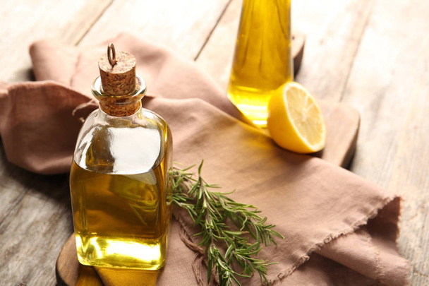 Composition with bottle of rosemary oil on wooden background - Fotoğraf, Görsel