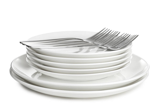 Stack of ceramic dishware with cutlery on white background - Zdjęcie, obraz