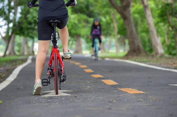 За азиатскими женщинами-велосипедистками перчатка на руле велосипеда
.  - Фото, изображение