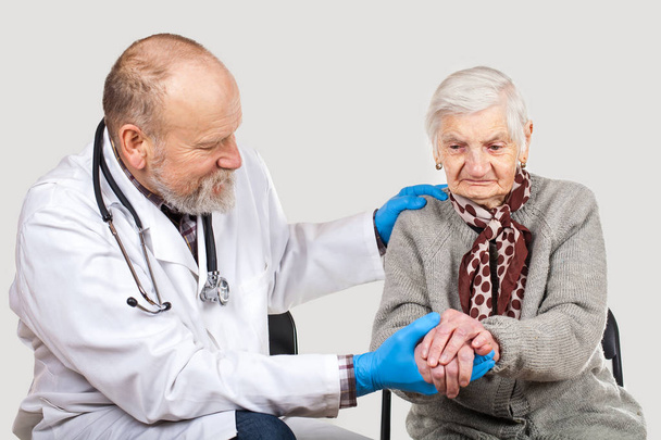 Kypsä mies lääkäri huolehtii vammaisten vanha nainen eristetty tausta
 - Valokuva, kuva