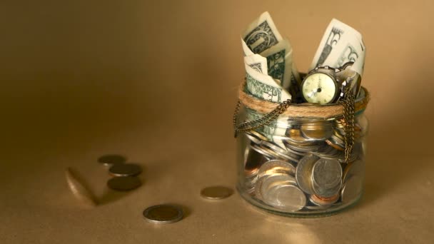 瓶の中のお金コインを保存しています。お金の概念を維持投資のシンボルです。貯金箱としてガラス錫現金紙幣を収集 - 映像、動画