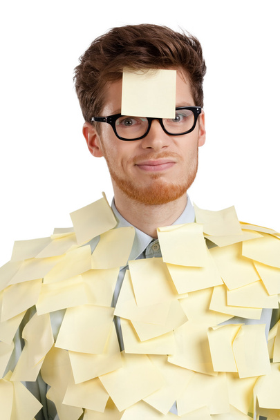 Unhappy young man with a sticky note on his face, covered with stickers - Foto, Imagem