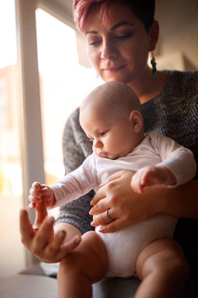 Baby playing mother's finger - Fotoğraf, Görsel