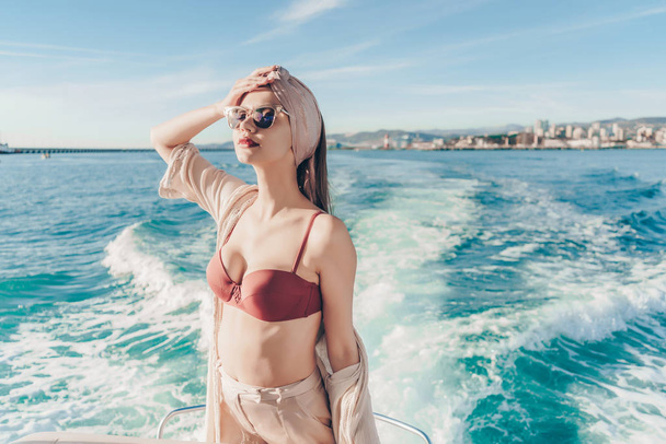 a luxurious stylish girl in sunglasses swims the Caribbean sea, enjoys a holiday on a yacht - Photo, Image