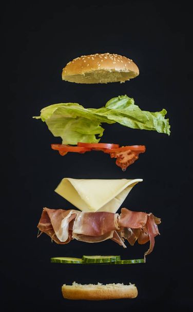 Leckerer Schinken mit Salatsandwich, schwebende Zutaten wie Schinkensalatbrot, Käse - Foto, Bild