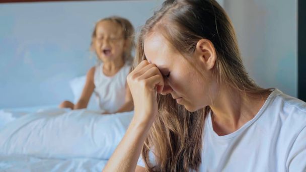 Upset mother with angry little child screaming pillow on the background - Photo, Image