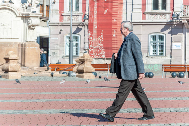 Temesvár, Románia - 2018. március 15.: öreg ember sétál az utcán. Valódi emberek. Hátulsó nézet. - Fotó, kép