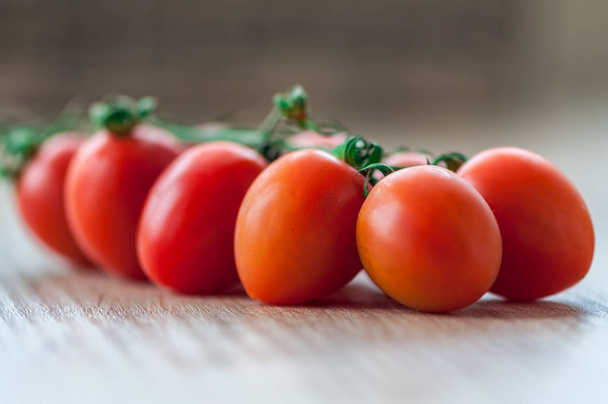 Close-up van cherry tomaten op een houten tafel. Ondiepe scherptediepte. - Foto, afbeelding