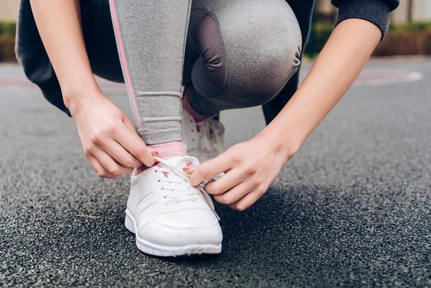 дівчина зв'язує свої шнурки на спортивних кросівок, готується до бігу на відкритому повітрі
 - Фото, зображення