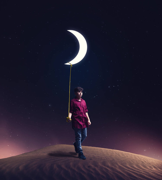 niño arrastra la luna hacia él con una cuerda en medio de la noche. El concepto de cumplir sus sueños
 - Foto, imagen