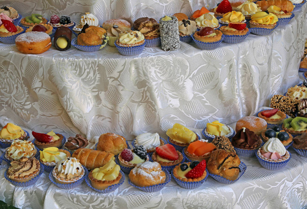 Assortimento di pasticceria mignon con molti dolci con panna e frutta fresca
 - Foto, immagini