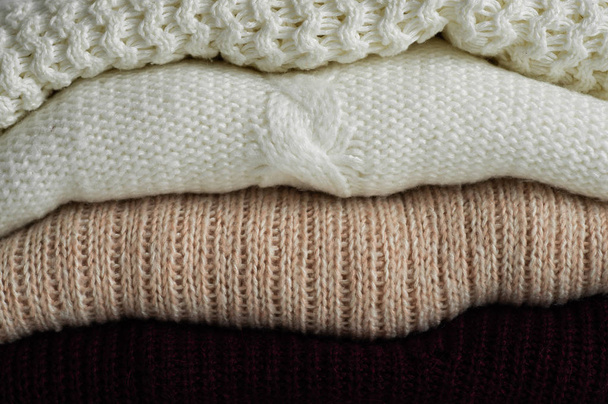 暖かいセーター。暖かい背景、セーター、ニット、秋冬のコンセプトのテキストのためのスペースのニット服の山。コピー スペース - 写真・画像