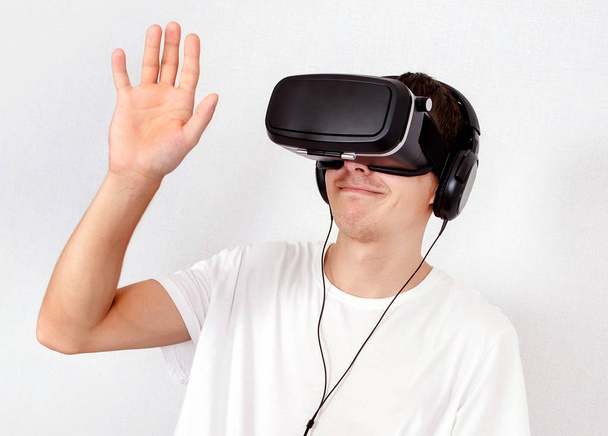Fiatal férfi a virtuális valóság maszk a fal - Fotó, kép