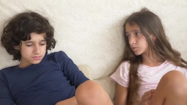 Teenager, Zwillinge, Bruder und Schwester streiten sich, sitzen auf der Couch. 4k, Zeitlupe, Nahaufnahme. - Filmmaterial, Video