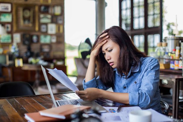 Νεαρή γυναίκα που κάθεται σε μια καφετέρια με το laptop, Stressful για εργασία. - Φωτογραφία, εικόνα