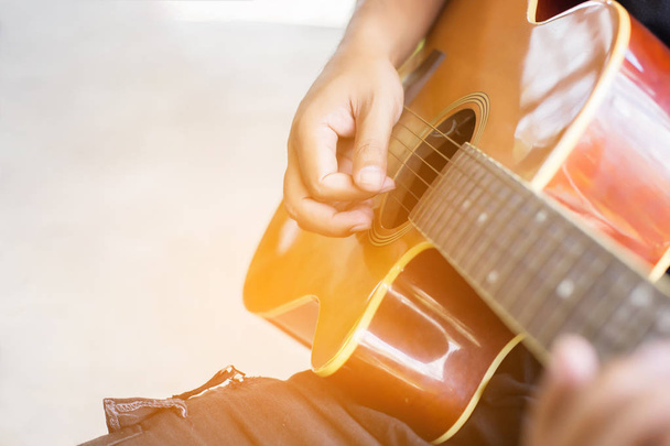 Close-up van iemands hand gitaar spelen. - Foto, afbeelding