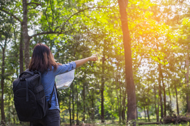 Γυναίκες πεζοπόρος με σακίδιο ελέγχει χάρτη για να βρείτε οδηγίες στην περιοχή άγριας φύσης - Φωτογραφία, εικόνα