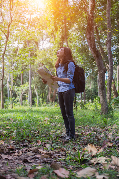 Femme randonneur avec sac à dos vérifie la carte pour trouver des directions dans la région sauvage
 - Photo, image