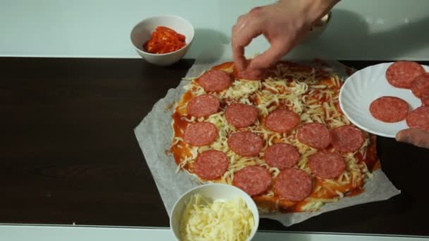 Kucharz, zakładanie surowego pizza salami na ser - Materiał filmowy, wideo