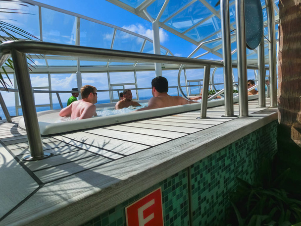 Fort Lauderdale, USA - April 30, 2018: The people rest in the Jacuzzi pool at upper deck at cruise liner or ship Oasis of the Seas by Royal Caribbean - Photo, Image