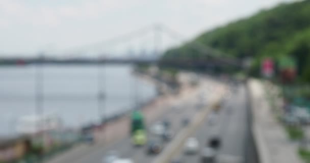 Panorama met uitzicht op de brug, water, vervoer over water, stadsauto's in vervagen bokeh reflexen, wazig silhouetten, daglicht, reizen - Video
