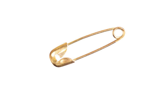 Macro shot of a golden safety pin isolated on white - Φωτογραφία, εικόνα