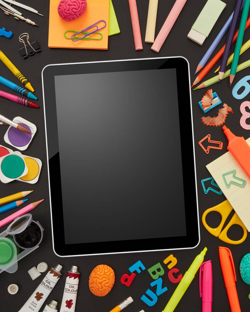 Digital tablet and school supplies on blackboard - Φωτογραφία, εικόνα