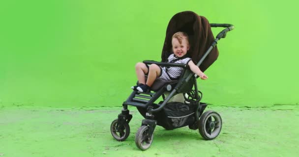 Portret urocze dziecko w wózek na ulicy - Materiał filmowy, wideo