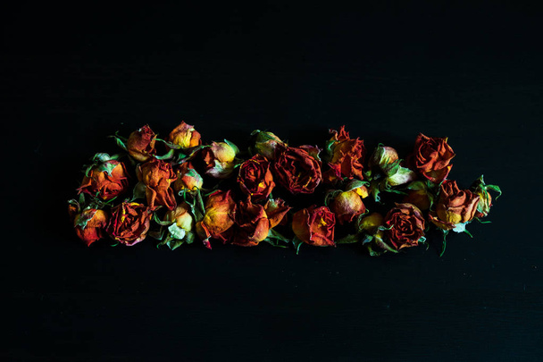 Background with dried red roses on dark. - Valokuva, kuva