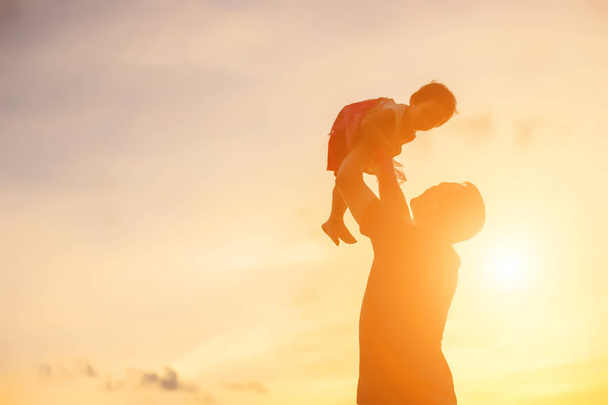 Otec vzal dítě na procházku při západu slunce. - Fotografie, Obrázek