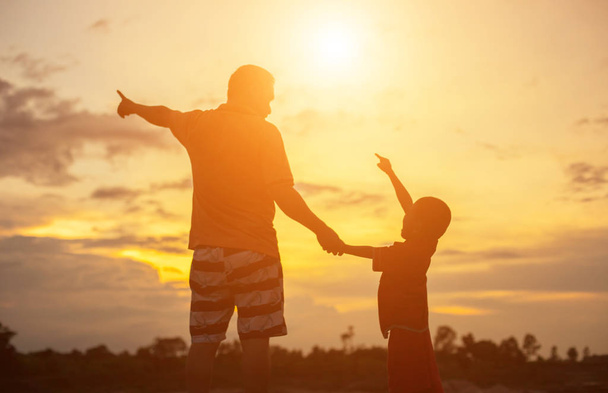 Happy dad throws the baby at sunset  - Photo, Image