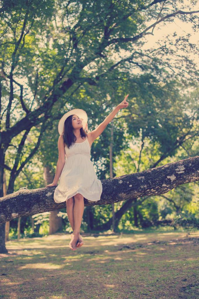 Joven adolescente chica sentado en árbol
  - Foto, Imagen