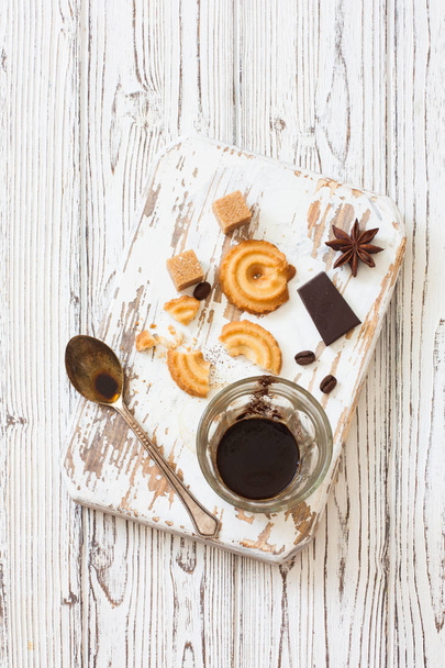 Glass of Black Coffee , Coffee Beans, Brown sugar and Cookies on a white wood background. Top view - Foto, Imagem