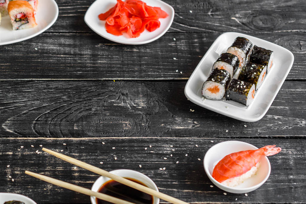 Sushi fresco y sabroso sobre fondo oscuro. Se puede utilizar como fondo
 - Foto, imagen