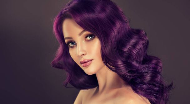 schönes Mädchen mit violetten, lockigen Haaren auf dem Hintergrund - Foto, Bild