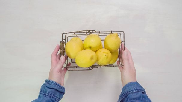 Step by step. Slicing fresh organic lemons on a white wood cutting board. - Zdjęcie, obraz