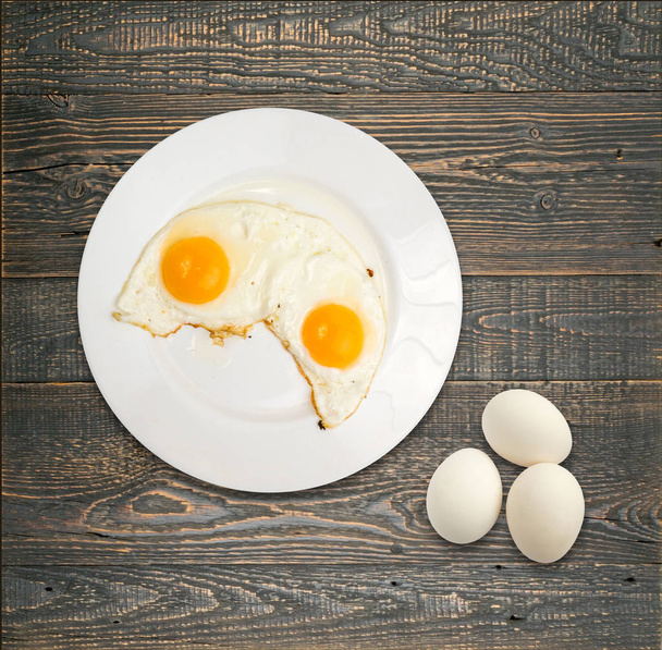 Two Fried Eggs on White Plate on Wooden Backgroynd Top View and Flat Lay - Photo, Image