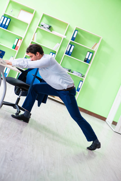 Employee doing exercises during break at work - Foto, afbeelding