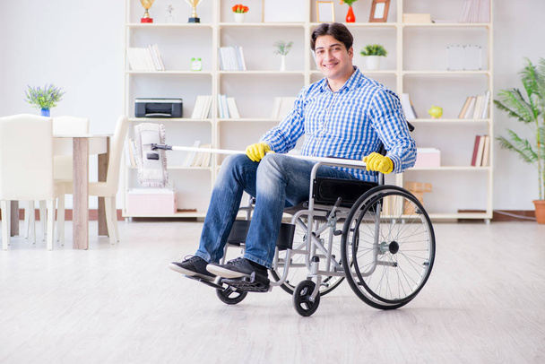 Gehandicapte man op rolstoel schoonmaken huis - Foto, afbeelding