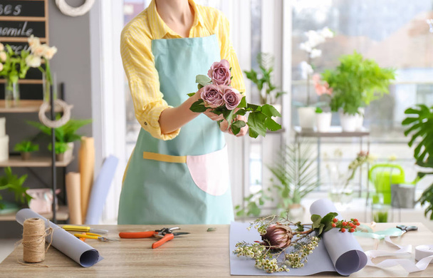 Female florist with roses at workplace - Valokuva, kuva