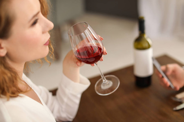 Woman with glass of wine at table in restaurant - Foto, Imagen