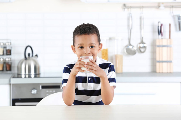 Adorable African-American boy with glass of milk in kitchen - Fotografie, Obrázek