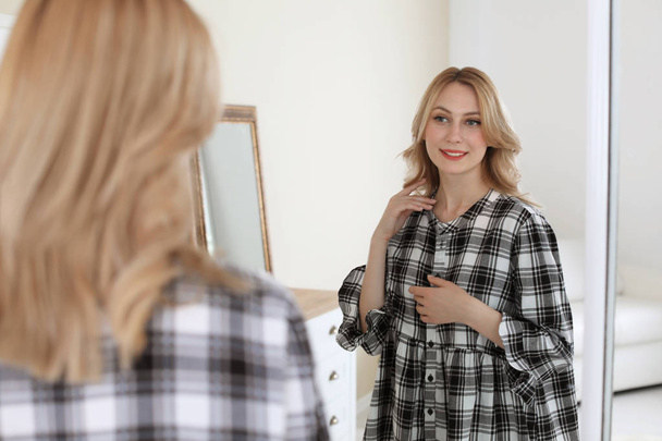 Young beautiful woman near mirror in makeup room - Фото, изображение