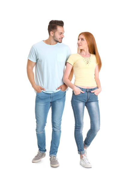 Young couple in stylish jeans on white background - Fotoğraf, Görsel