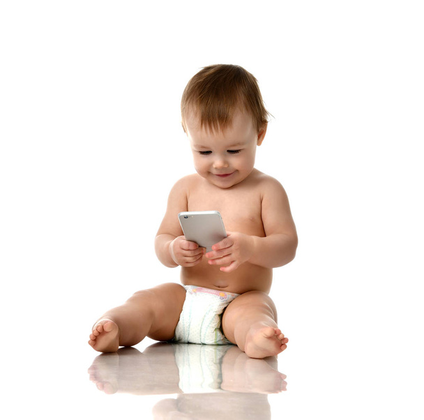 Infant child baby girl toddler playing with mobile cellphone happy smiling - Foto, Bild