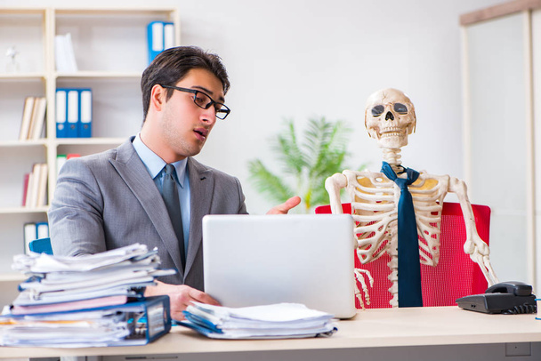 Üzletember dolgozik csontváz az irodában - Fotó, kép